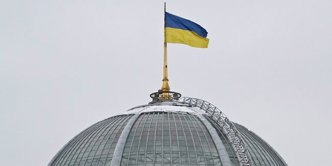 Желто-голубой флаг на здании высшего законодательного органа государства символизировал начало новой эпохи для истерзанной страны